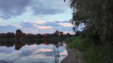 Çok güzel bir gün batımı ve su. Yaz akşamı manzarası. Sudaki bulutların yansıması. Güneş ufukta batıyor. Göllü yaz manzarası. Sudaki ağaçların yansıması. Nehirde gün doğumu. şehvetli bulutlar.