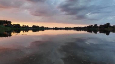 Çok güzel bir gün batımı ve su. Yaz akşamı manzarası. Sudaki bulutların yansıması. Güneş ufukta batıyor. Göllü yaz manzarası. Sudaki ağaçların yansıması. Nehirde gün doğumu. şehvetli bulutlar.
