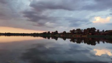 Çok güzel bir gün batımı ve su. Yaz akşamı manzarası. Sudaki bulutların yansıması. Güneş ufukta batıyor. Göllü yaz manzarası. Sudaki ağaçların yansıması. Nehirde gün doğumu. şehvetli bulutlar.
