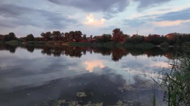 Çok güzel bir gün batımı ve su. Yaz akşamı manzarası. Sudaki bulutların yansıması. Güneş ufukta batıyor. Göllü yaz manzarası. Sudaki ağaçların yansıması. Nehirde gün doğumu. şehvetli bulutlar.