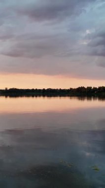 Çok güzel bir gün batımı ve su. Yaz akşamı manzarası. Sudaki bulutların yansıması. Güneş ufukta batıyor. Göllü yaz manzarası. Sudaki ağaçların yansıması. Nehirde gün doğumu. şehvetli bulutlar.