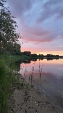 Çok güzel bir gün batımı ve su. Yaz akşamı manzarası. Sudaki bulutların yansıması. Güneş ufukta batıyor. Göllü yaz manzarası. Sudaki ağaçların yansıması. Nehirde gün doğumu. şehvetli bulutlar.
