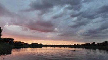 Çok güzel bir gün batımı ve su. Yaz akşamı manzarası. Sudaki bulutların yansıması. Güneş ufukta batıyor. Göllü yaz manzarası. Sudaki ağaçların yansıması. Nehirde gün doğumu. şehvetli bulutlar.