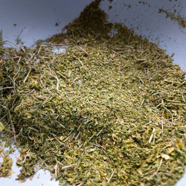 Kuru ve ezilmiş ot. Elinde tütün var. Yiyecek için ezilmiş baharatlar. Kuru dereotu ve maydanoz. Kuru fesleğen. Yemek için baharat. kuru kenevir.