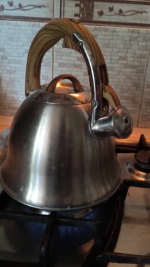 Ocakta ıslık çalan çaydanlık. Gaz ocağındaki su ısıtıcısı. Çaydanlıkta kaynamış bir adam. Parlak metal çaydanlık.