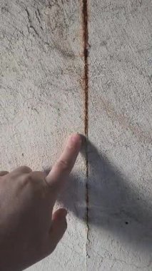 Duvarda pas var. Adam eliyle duvara dokunuyor. Çürük ahşap uzay araçlarıyla paslanmadan dolayı çinko çatı sızdırıyor.