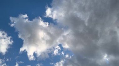 Mavi gökyüzü ve beyaz bulutlar. Gökyüzündeki ışık huzmeleri. Gökyüzündeki güneş. Doğanın doğal videosu. 4k doğal video. doğal arkaplan.