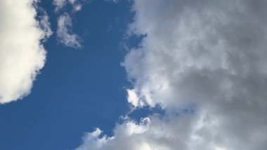 Mavi gökyüzü ve beyaz bulutlar. Gökyüzündeki ışık huzmeleri. Gökyüzündeki güneş. Doğanın doğal videosu. 4k doğal video. doğal arkaplan.