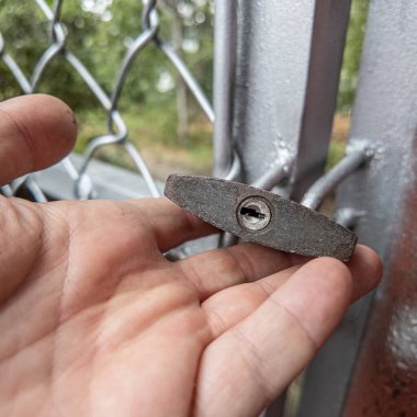 Eski asma kilit. Adam eski metal kilidi açıyor. Eski evdeki ahşap kapı. Dükkanını asma kilit ve metal kepenkle kapatan bir adam. Yakın plan. 4K Çözünürlüğü.