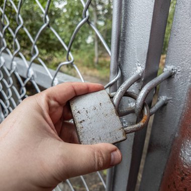 Eski asma kilit. Adam eski metal kilidi açıyor. Eski evdeki ahşap kapı. Dükkanını asma kilit ve metal kepenkle kapatan bir adam. Yakın plan. 4K Çözünürlüğü.