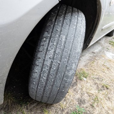 Çok yıpranmış araba lastikleri. Yakın plan bir arabanın eski lastikleri. Yoldaki çukurlarla kaplı hasarlı bir otoyolda giden araç lastiği. POV kamerası yana bağlandı