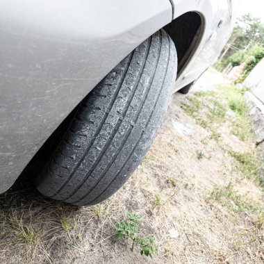 Çok yıpranmış araba lastikleri. Yakın plan bir arabanın eski lastikleri. Yoldaki çukurlarla kaplı hasarlı bir otoyolda giden araç lastiği. POV kamerası yana bağlandı