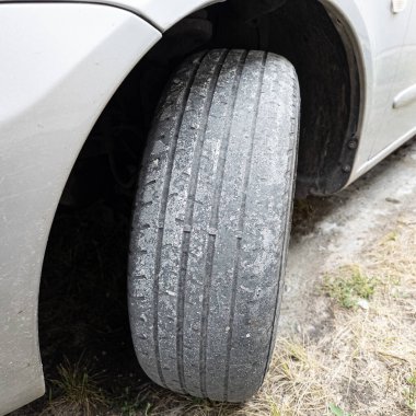 Çok yıpranmış araba lastikleri. Yakın plan bir arabanın eski lastikleri. Yoldaki çukurlarla kaplı hasarlı bir otoyolda giden araç lastiği. POV kamerası yana bağlandı