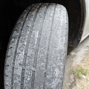 Çok yıpranmış araba lastikleri. Yakın plan bir arabanın eski lastikleri. Yoldaki çukurlarla kaplı hasarlı bir otoyolda giden araç lastiği. POV kamerası yana bağlandı