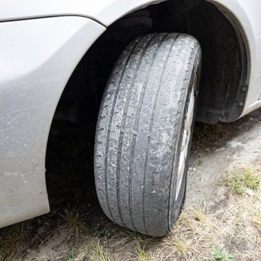 Çok yıpranmış araba lastikleri. Yakın plan bir arabanın eski lastikleri. Yoldaki çukurlarla kaplı hasarlı bir otoyolda giden araç lastiği. POV kamerası yana bağlandı