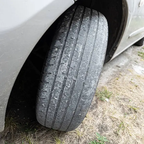 Çok yıpranmış araba lastikleri. Yakın plan bir arabanın eski lastikleri. Yoldaki çukurlarla kaplı hasarlı bir otoyolda giden araç lastiği. POV kamerası yana bağlandı