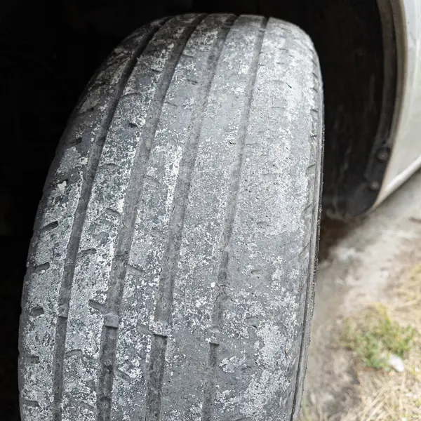 Çok yıpranmış araba lastikleri. Yakın plan bir arabanın eski lastikleri. Yoldaki çukurlarla kaplı hasarlı bir otoyolda giden araç lastiği. POV kamerası yana bağlandı