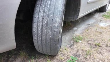 Çok yıpranmış araba lastikleri. Yakın plan bir arabanın eski lastikleri. Yoldaki çukurlarla kaplı hasarlı bir otoyolda giden araç lastiği. POV kamerası yana bağlandı