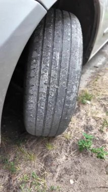 Çok yıpranmış araba lastikleri. Yakın plan bir arabanın eski lastikleri. Yoldaki çukurlarla kaplı hasarlı bir otoyolda giden araç lastiği. POV kamerası yana bağlandı