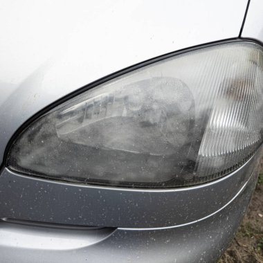 Eski araba farları. Yansıtıcı far. Halojen ışığı. Eski bir SUV 'nin yakın plan farı. Kirli far ve beyaz bir otomobilin tamponu..