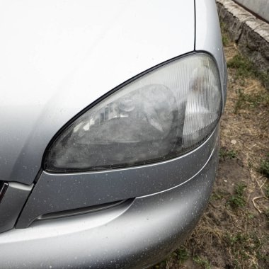 Eski araba farları. Yansıtıcı far. Halojen ışığı. Eski bir SUV 'nin yakın plan farı. Kirli far ve beyaz bir otomobilin tamponu..