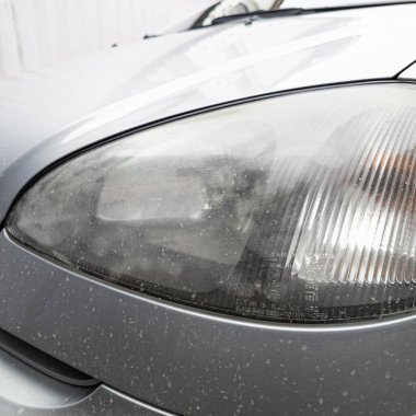 Eski araba farları. Yansıtıcı far. Halojen ışığı. Eski bir SUV 'nin yakın plan farı. Kirli far ve beyaz bir otomobilin tamponu..