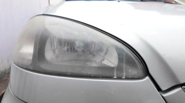 Eski araba farları. Yansıtıcı far. Halojen ışığı. Eski bir SUV 'nin yakın plan farı. Kirli far ve beyaz bir otomobilin tamponu..