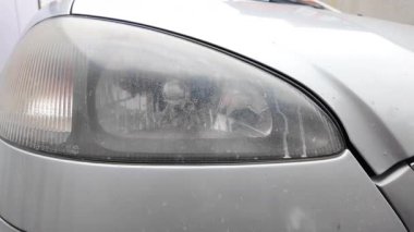 Eski araba farları. Yansıtıcı far. Halojen ışığı. Eski bir SUV 'nin yakın plan farı. Kirli far ve beyaz bir otomobilin tamponu..