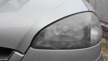 Eski araba farları. Yansıtıcı far. Halojen ışığı. Eski bir SUV 'nin yakın plan farı. Kirli far ve beyaz bir otomobilin tamponu..