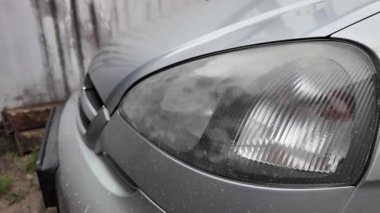 Eski araba farları. Yansıtıcı far. Halojen ışığı. Eski bir SUV 'nin yakın plan farı. Kirli far ve beyaz bir otomobilin tamponu..