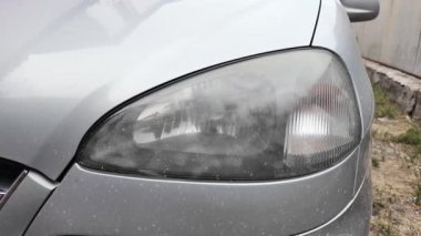 Eski araba farları. Yansıtıcı far. Halojen ışığı. Eski bir SUV 'nin yakın plan farı. Kirli far ve beyaz bir otomobilin tamponu..