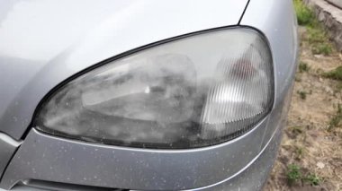 Eski araba farları. Yansıtıcı far. Halojen ışığı. Eski bir SUV 'nin yakın plan farı. Kirli far ve beyaz bir otomobilin tamponu..