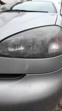 Eski araba farları. Yansıtıcı far. Halojen ışığı. Eski bir SUV 'nin yakın plan farı. Kirli far ve beyaz bir otomobilin tamponu..