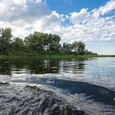 Göldeki suyun yavaş çekim videosu. Dalgalar yavaş çekimde köpük saçıyor. Sıcak gün batımının yüzeydeki yansımaları ile çekilen sakin su hareketi.