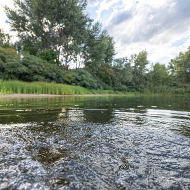 Göldeki suyun yavaş çekim videosu. Dalgalar yavaş çekimde köpük saçıyor. Sıcak gün batımının yüzeydeki yansımaları ile çekilen sakin su hareketi.