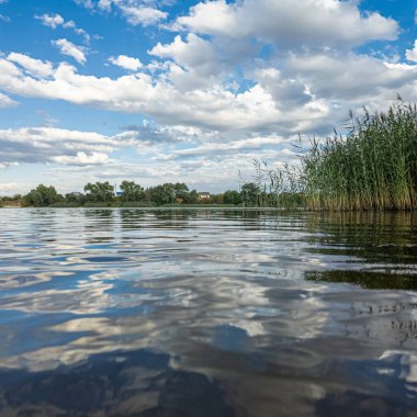 Göldeki suyun yavaş çekim videosu. Dalgalar yavaş çekimde köpük saçıyor. Sıcak gün batımının yüzeydeki yansımaları ile çekilen sakin su hareketi.