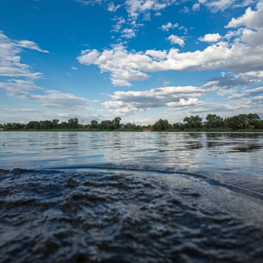 Göldeki suyun yavaş çekim videosu. Dalgalar yavaş çekimde köpük saçıyor. Sıcak gün batımının yüzeydeki yansımaları ile çekilen sakin su hareketi.