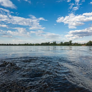 Göldeki suyun yavaş çekim videosu. Dalgalar yavaş çekimde köpük saçıyor. Sıcak gün batımının yüzeydeki yansımaları ile çekilen sakin su hareketi.