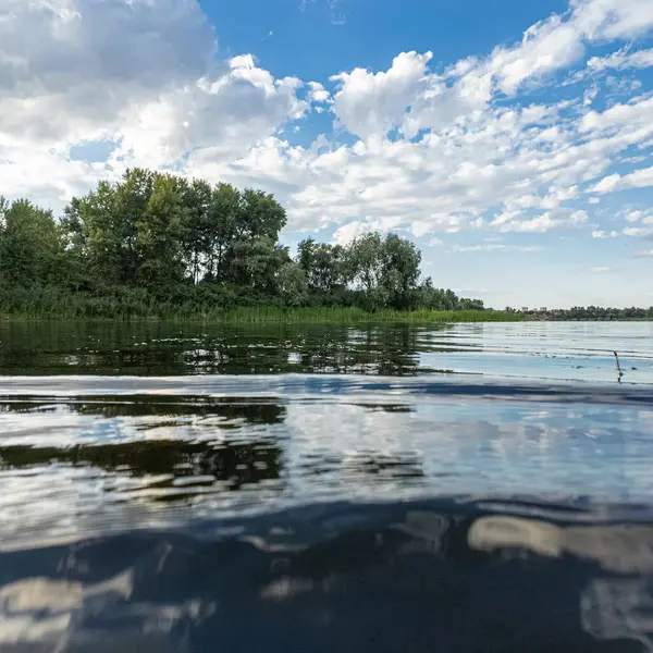 Göldeki suyun yavaş çekim videosu. Dalgalar yavaş çekimde köpük saçıyor. Sıcak gün batımının yüzeydeki yansımaları ile çekilen sakin su hareketi.