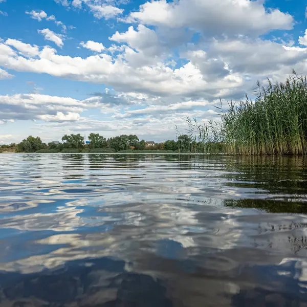 Göldeki suyun yavaş çekim videosu. Dalgalar yavaş çekimde köpük saçıyor. Sıcak gün batımının yüzeydeki yansımaları ile çekilen sakin su hareketi.