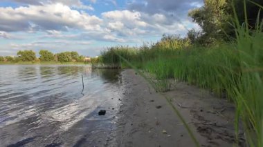 Bulutlar suda yansıyor. Gökyüzü ve nehir. Göllü doğal manzara. Göl üzerinde yağmur bulutları. Nehirdeki pürüzsüz karanlık su. Yavaş çekim video doğal manzara. Doğa geçmişi. 4k çözünürlüğü