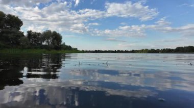 Göldeki suyun yavaş çekim videosu. Dalgalar yavaş çekimde köpük saçıyor. Sıcak gün batımının yüzeydeki yansımaları ile çekilen sakin su hareketi.
