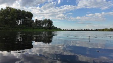 Göldeki suyun yavaş çekim videosu. Dalgalar yavaş çekimde köpük saçıyor. Sıcak gün batımının yüzeydeki yansımaları ile çekilen sakin su hareketi.
