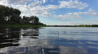 Göldeki suyun yavaş çekim videosu. Dalgalar yavaş çekimde köpük saçıyor. Sıcak gün batımının yüzeydeki yansımaları ile çekilen sakin su hareketi.