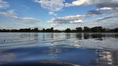 Göldeki suyun yavaş çekim videosu. Dalgalar yavaş çekimde köpük saçıyor. Sıcak gün batımının yüzeydeki yansımaları ile çekilen sakin su hareketi.