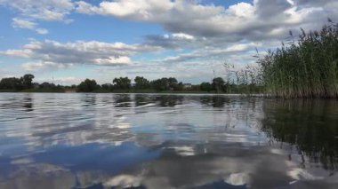 Göldeki suyun yavaş çekim videosu. Dalgalar yavaş çekimde köpük saçıyor. Sıcak gün batımının yüzeydeki yansımaları ile çekilen sakin su hareketi.