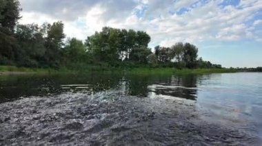 Göldeki suyun yavaş çekim videosu. Dalgalar yavaş çekimde köpük saçıyor. Sıcak gün batımının yüzeydeki yansımaları ile çekilen sakin su hareketi.