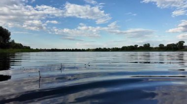 Göldeki suyun yavaş çekim videosu. Dalgalar yavaş çekimde köpük saçıyor. Sıcak gün batımının yüzeydeki yansımaları ile çekilen sakin su hareketi.