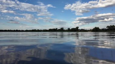 Göldeki suyun yavaş çekim videosu. Dalgalar yavaş çekimde köpük saçıyor. Sıcak gün batımının yüzeydeki yansımaları ile çekilen sakin su hareketi.