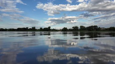 Göldeki suyun yavaş çekim videosu. Dalgalar yavaş çekimde köpük saçıyor. Sıcak gün batımının yüzeydeki yansımaları ile çekilen sakin su hareketi.